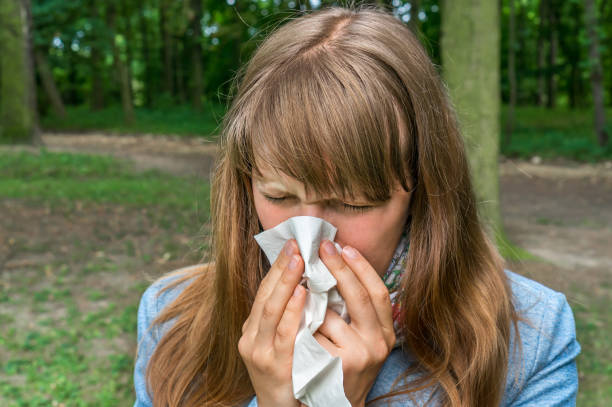 istock Woman with flu or allergy symptoms in park 825092232