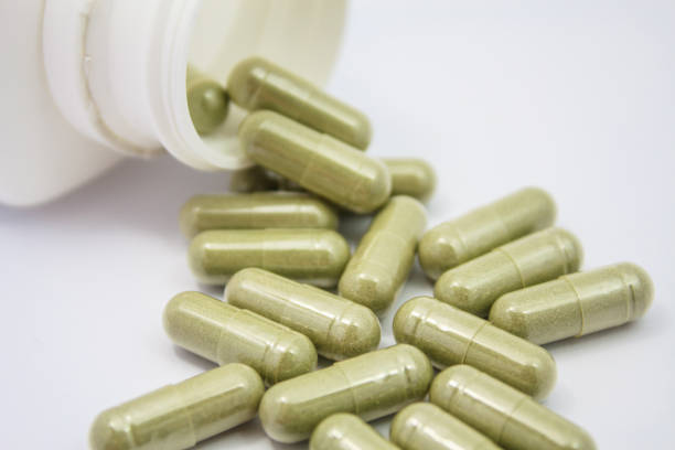 istock herbal capsules spilling out of a bottle 825106714