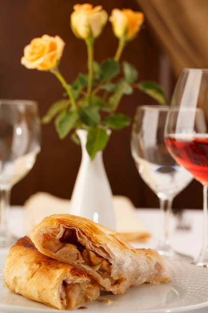 istock Apple pie slice arranged on a plate, Wineglass in background, Traditional dessert in elegant setting, Selective focus with soft light 825109026