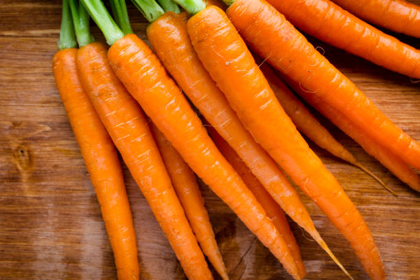 istock Fresh carrots on the wooden background. 825118946