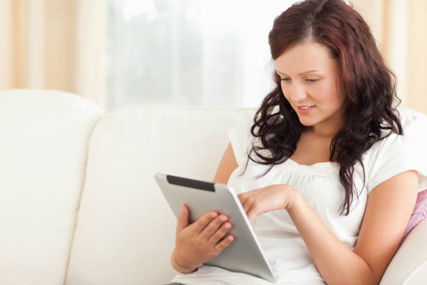 istock woman with a tablet on a sofa 825122332
