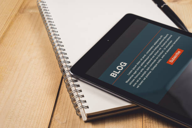 istock Tablet with Blog on screen on notebook paper 825128812