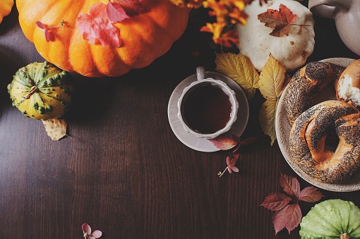 cozy autumn breakfast at country house with tea, bagel and seasonal decorations