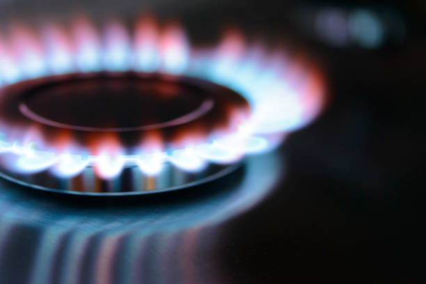 Blue and orange flames on a gas stove burner Blue and orange flames on a gas stove burner with a dark background. liquefied petroleum gas photos stock pictures, royalty-free photos & images