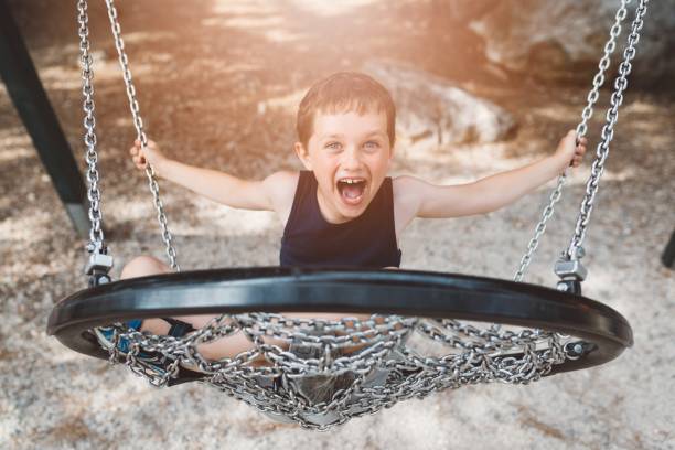 istock Little boy child having fun on child swing 825139450