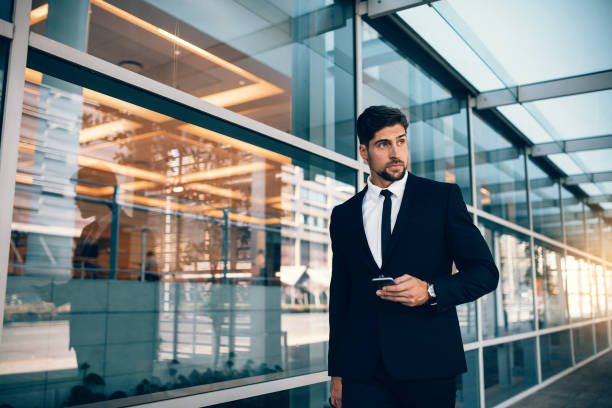 istock Handsome businessman walking with mobile phone 825145548