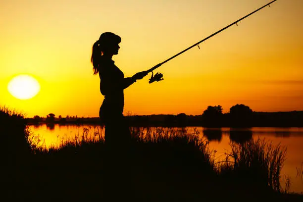 Photo of Silhouette of a woman engaged in sport fishing
