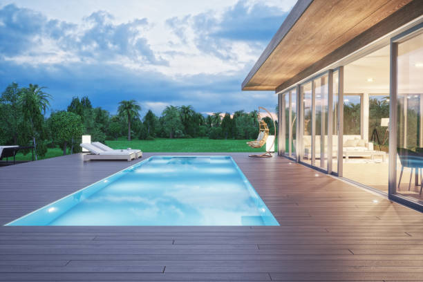 Modern Luxury House With Swimming Pool At Dawn Modern luxury villa with swimming pool and forest view at dawn. deck stock pictures, royalty-free photos & images