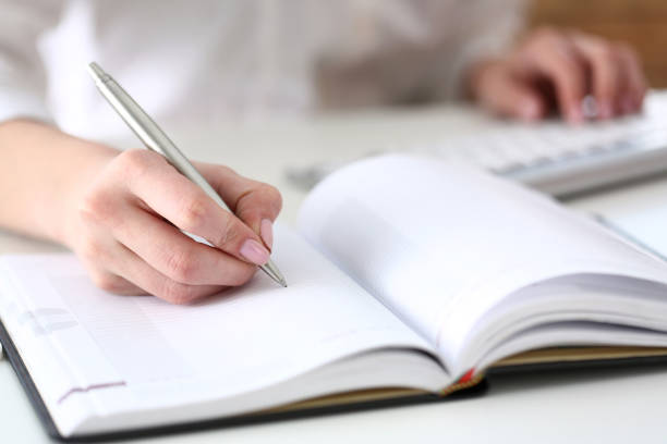 istock Female hand holding silver pen ready to make note 825155038
