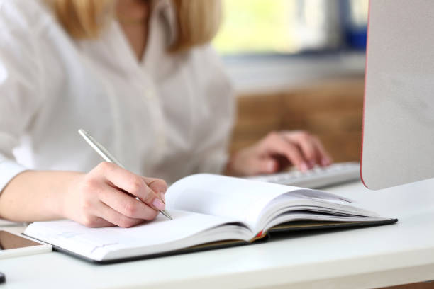 istock Female hand holding silver pen ready to make note 825155062