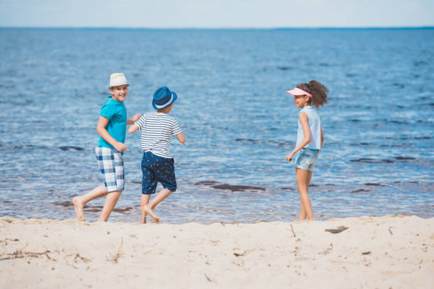 istock Multicultural group of little children playing together on beach 825159150