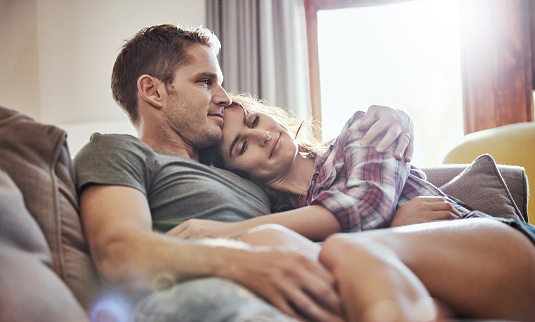 Shot of a young couple relaxing together on the sofa at home