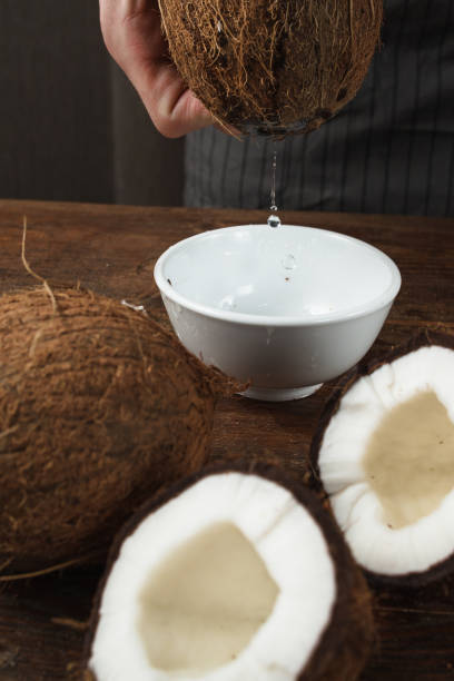 istock Fresh coconut water pouring into white bowl 825159686
