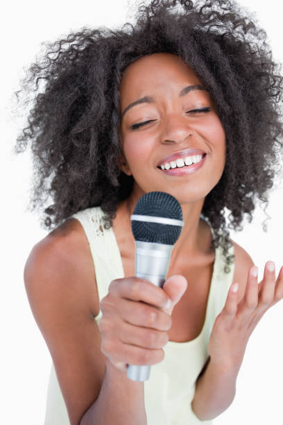 istock Concentrated young woman singing into a microphone 825160630