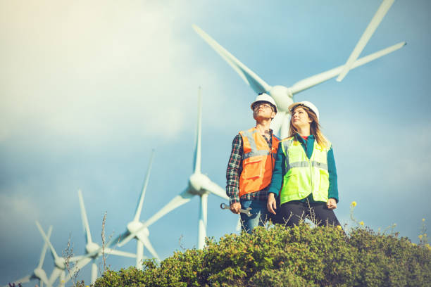 istock Young engineers looking and checking wind turbines at field 825171024