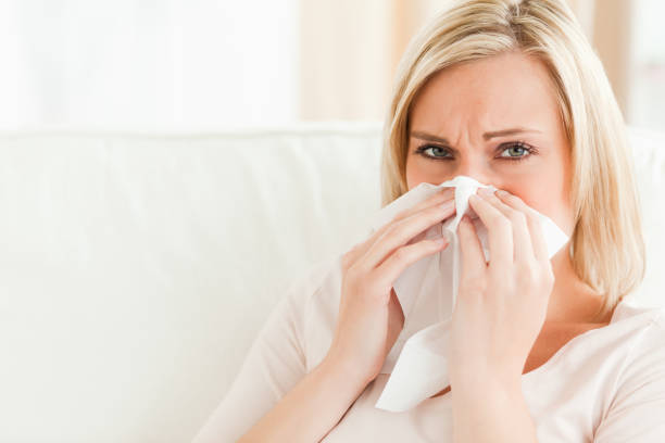 istock Sick woman blowing her nose 825171354