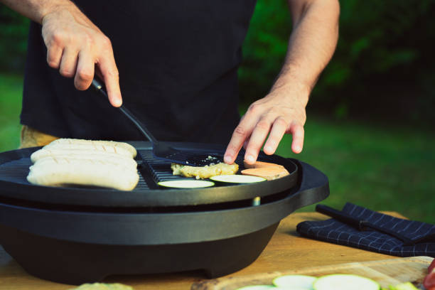 istock Unrecognisable man using electric grill. Garden grill party concept 825177026