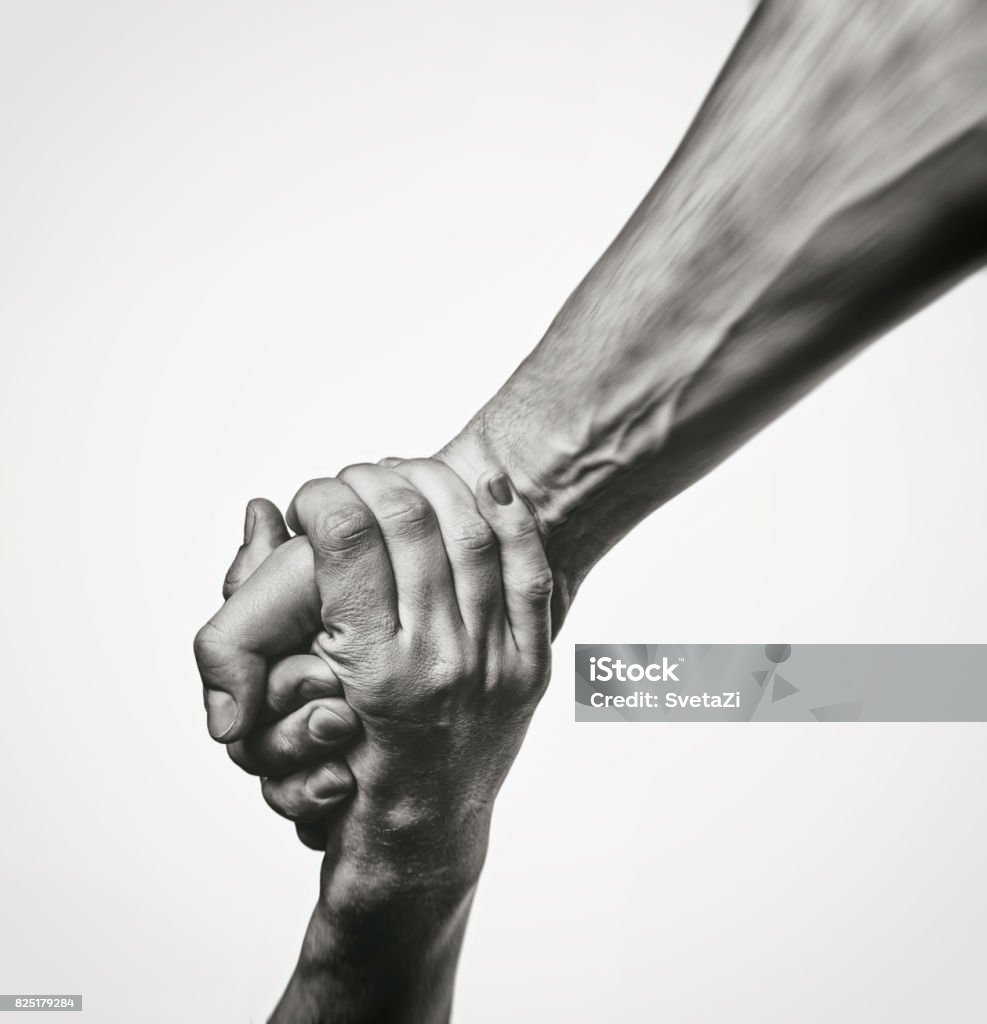 Concept of salvation Concept of salvation. Black and white image of the hands of two people at the time of rescue (help). A Helping Hand Stock Photo