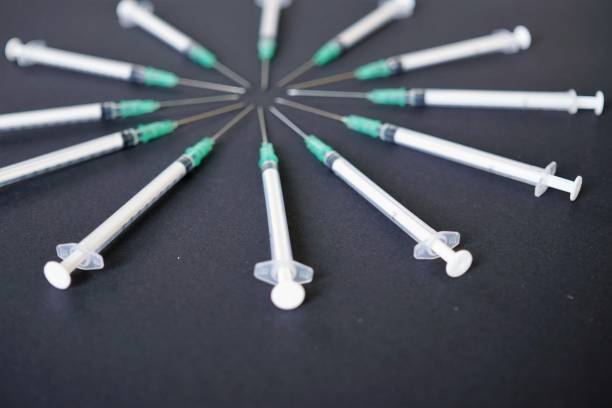 istock Syringes in circle on black background 825179860