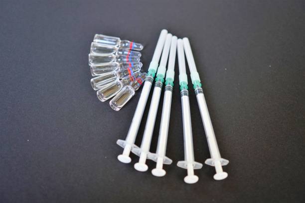 istock Ampoules and syringes on black background. Selective focus 825180022