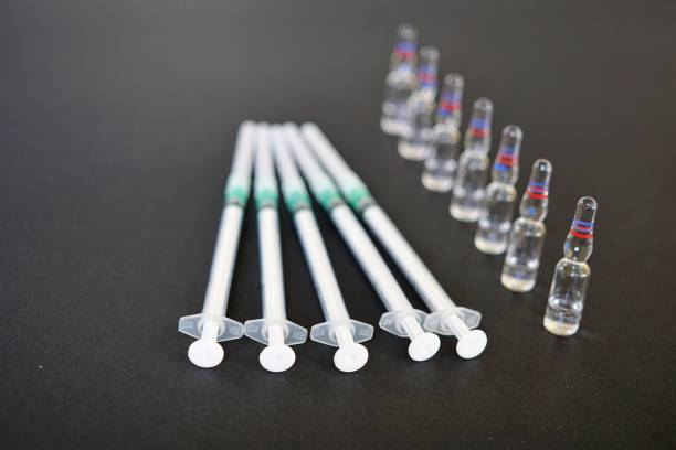 istock Ampoules and syringes on black background. Selective focus 825180028