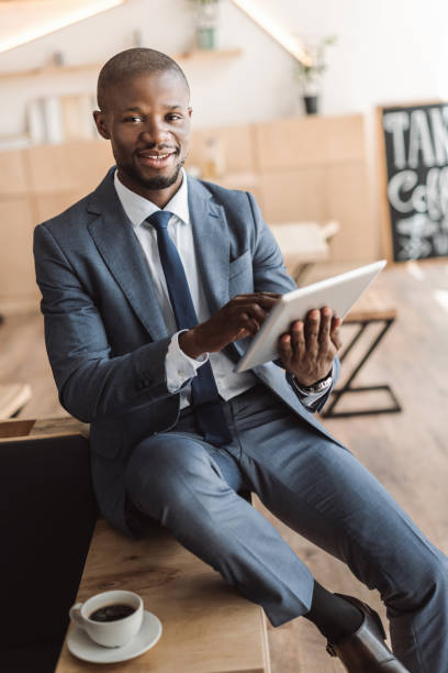 istock handsome african american businessman using digital tablet during coffee break in cafe 825180128