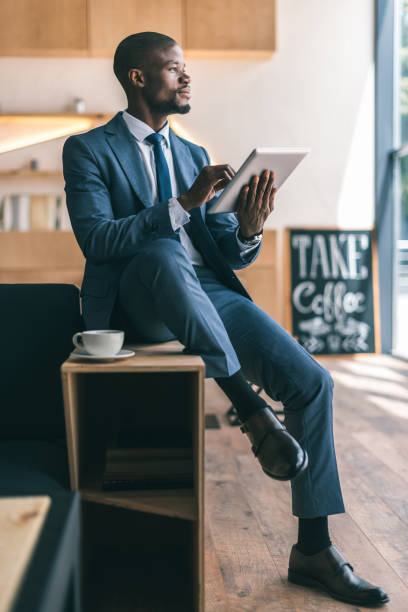 istock handsome thoughtful african american businessman using digital tablet during coffee break in cafe 825181572