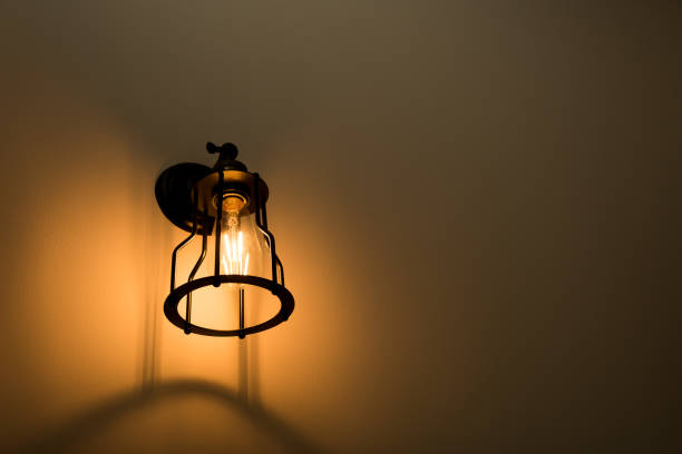 istock Wall lamp with yellow shade on cement wall. 825182140