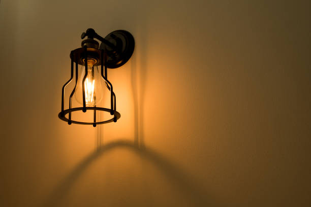 istock Wall lamp with yellow shade on cement wall. 825182178