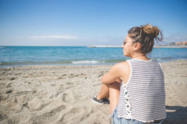 istock Young beautiful woman relaxing on beach smiling 825197894
