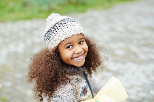 African-american girl in knitted beanie hat and cardigan