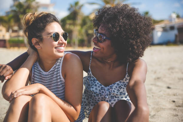 istock Two best female friends on beach looking at each other 825198330