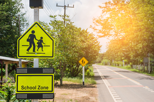 Yellow road and caution sign for crossing students near Thai school in rural small village Parangmee near Noen Maprang  in province Phitsanulok.