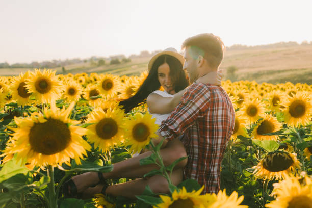 istock Couple embracing in sunflower field at sunset 825200856