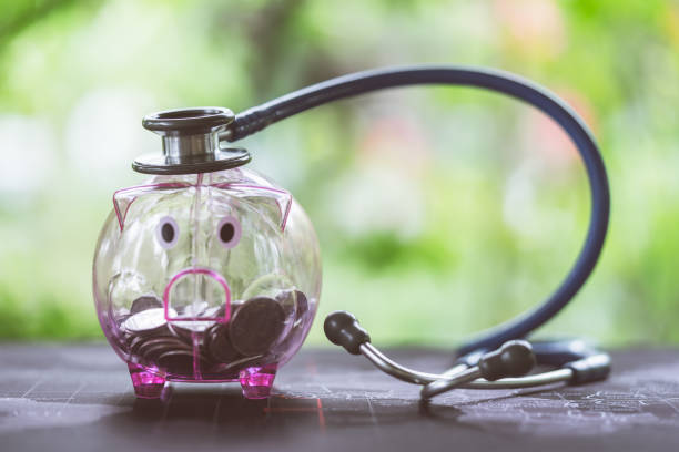 Stethoscope on piggy bank filled with coins, concept of Financial Health stock photo