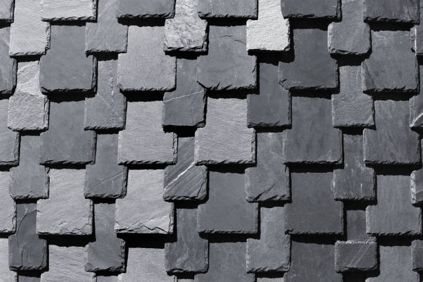 istock Overlapping stone slabs on a roof. Tiled shingles background 825204358