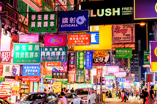Colorful billboard neon signs hang precariously on buildings along Nathan Road in Mongkok, one of the busiest and most popular commercial areas in Hong Kong and a favorite place for visitors and locals to hang out and explore.