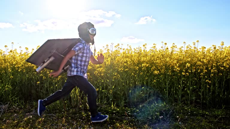 SLO MO Little boy dressed in an airplane costume punching the air with one arm