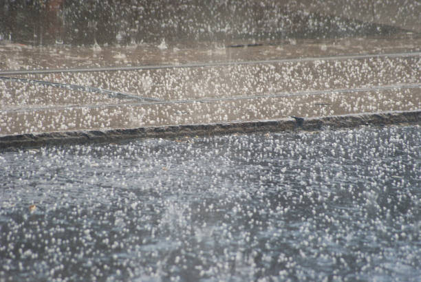 pluie et grêle qui tombe sur la ligne de tramway et de l’asphalte urbain - grêle photos et images de collection