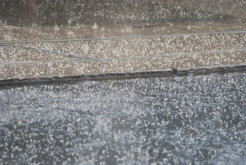 Rain and Hailstones falling on urban asphalt and tramline