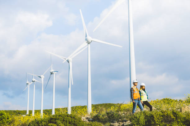 istock Young engineers looking and checking wind turbines at field 825214344