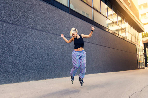 istock Cool young hipster woman jumping with roller skates 825214826