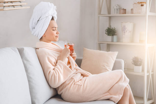 giovane donna cura del corpo a casa al chiuso - bathrobe women cup towel foto e immagini stock