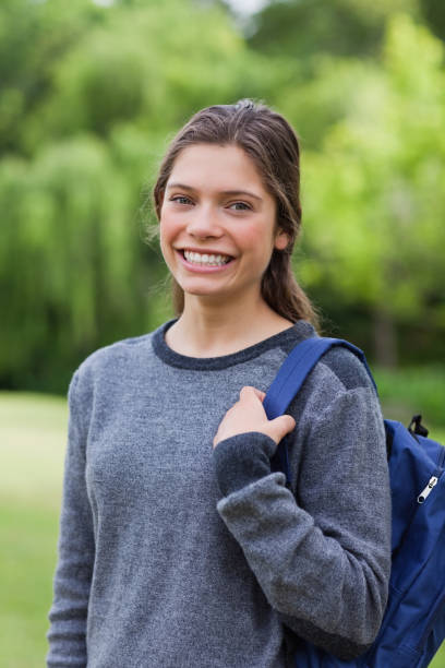 istock Young girl standing up with while carrying her backpack 825220210