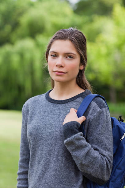 istock Young relaxed girl looking straight at the camera while standing in a park 825220244