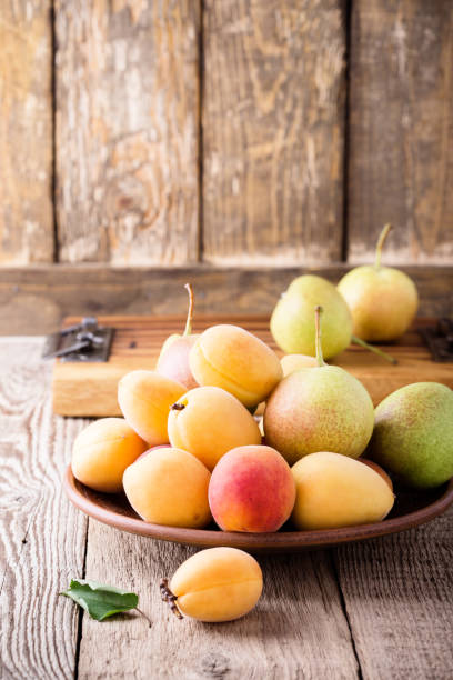 istock Ripe organic apricots and pears in ceramic bowl 825222946