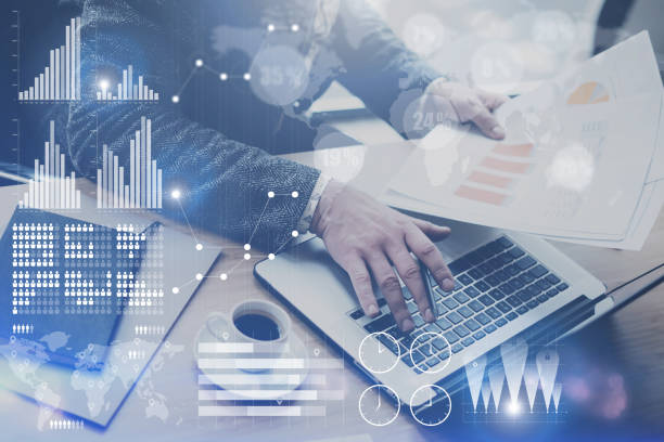 istock Concept of digital screen,virtual connection icon,diagram,graph interfaces.Businessman working at office on laptop.Man holding paper documents in hands.Blurred background. 825223254
