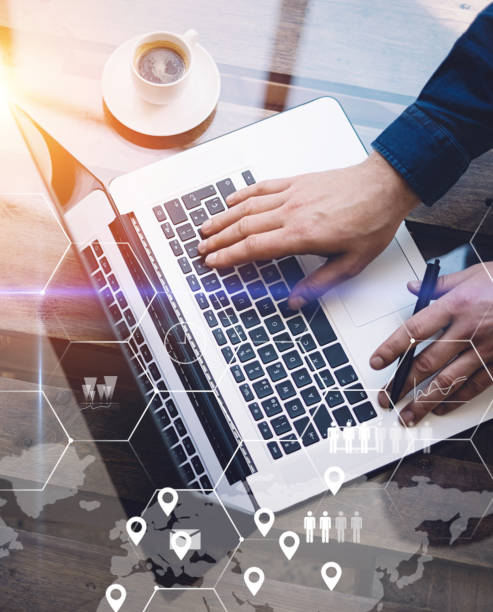 istock Concept of digital screen,virtual connection icon,diagram,graph interfaces.Man working with laptop at office at wooden table.Reflections on glass surface.Flares effect.Vertical. 825223492