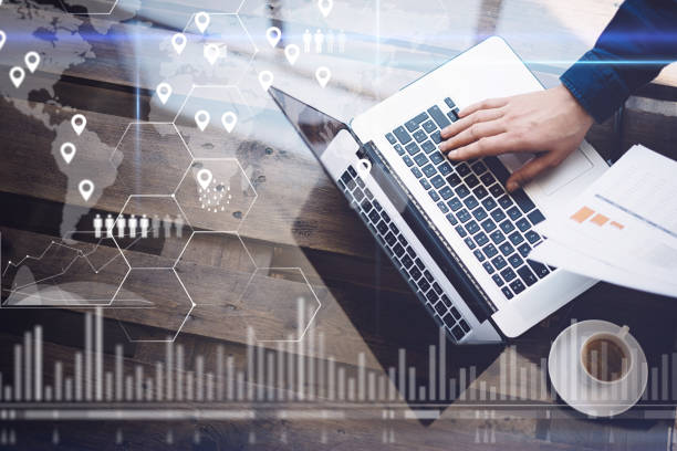 istock Concept of digital screen,geolocation icon,virtual diagram,graph interfaces.Man working with laptop at office at wooden table.Reflections on glass surface.Horizontal. 825223600