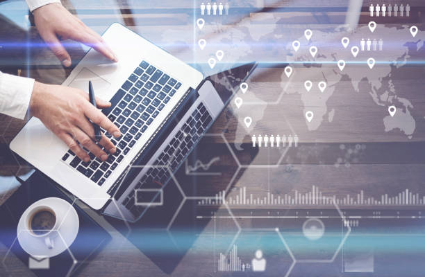 Concept of digital screen,virtual connection icon,diagram,graph interfaces.Businessman working with laptop at office.Modern notebook,cup of black coffee on wooden table.Reflections on glass surface.
